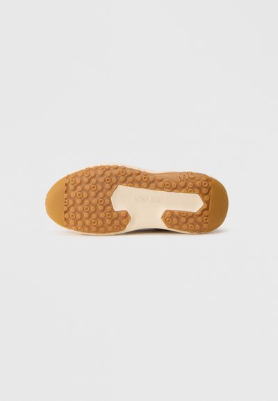 Sål på en beige og brun sko med cirkulære sålmønstre og "MOON BOOT" præget i midten.