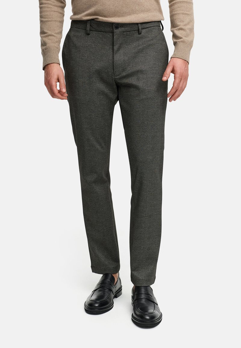 Pantalones de vestir a cuadros grises con un diseño ajustado, fabricados en un tejido texturizado, combinados con zapatos negros sin cordones.