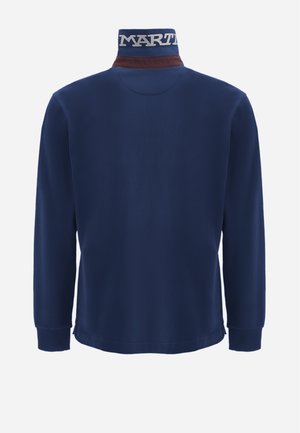 Camisa de manga larga azul marino con un alto cuello que presenta un acento marrón y el logo blanco "MART". Textura suave con puños acanalados.