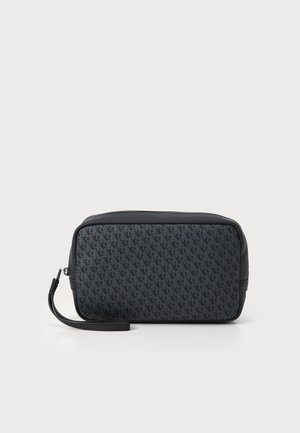 Bolsa de cremallera negra con una superficie texturizada y un patrón de logotipos repetido, de forma rectangular y con una correa de muñeca desmontable.