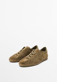 Sneaker in suede marrone con profilo basso, punta rotonda e chiusura con lacci. Unici motivi di cucitura diagonale e suola in gomma texture.