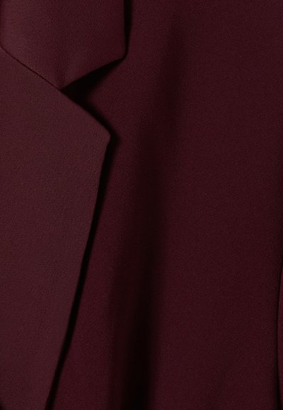 Tejido burdeos con una textura suave, que presenta paneles de tela superpuestos en un diseño moderno, creando un efecto de capas.