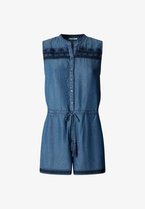 Mouwloze blauwe denim jumpsuit met knopen aan de voorkant, zwarte geborduurde accenten op de borst en zoom, en een tailleband met kwastjes.