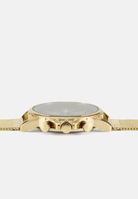 Montre chronographe en or avec bracelet en maille, cadran noir, trois boutons latéraux et une couronne proéminente. Présente un boîtier rond et un verre de protection.