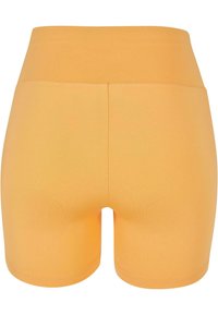 Kõrge vöökohaga sileda vöörihmaga ja nähtavate taskute või logodeta oranžid venivad suvepüksid.