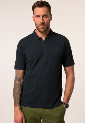 Polo de color marino con mangas cortas y cuello con media cremallera. Presenta un discreto detalle del logo en el pecho y una textura suave y agradable.