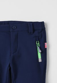 Navy blue pants with elastic waistband, featuring a side zippered pocket with green accents and a small Norway flag patch. Smooth texture.