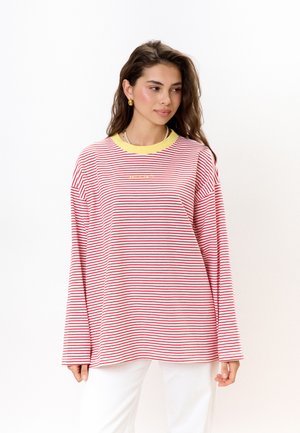 Rood-wit gestreepte longsleeve shirt met een gele halslijn en een klein tekstlogo op de borst. Zachte textuur, ontspannen pasvorm.