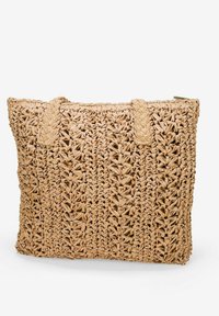 Bolso de tote de paja trenzada en color natural con asas trenzadas, que presenta una superficie texturizada y un diseño abierto. Cierre con cremallera en la parte superior.