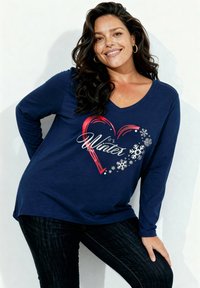 Granatowa koszulka z długim rękawem i dekoltem w serek, z czerwonym sercem, białymi płatkami śniegu i napisem "To jest czas zimy." Miękka faktura tkaniny.