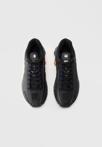 Czarne buty sportowe z siateczkową i syntetyczną cholewką, o fakturowanym wzorze, wyróżniające się pomarańczowymi akcentami i amortyzowaną podeszwą.