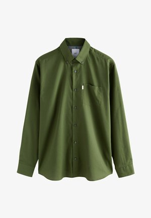 Olive rohelise värvusega pikkade varrukatega nööbitav särgipluus nööbitava krae ja rinnataskuga, mis on paigutatud lihtsale valgele taustale.