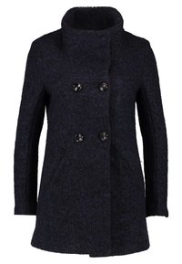 Cappotto di lana blu navy con colletto alto, chiusura doppiopetto e due tasche frontali. Presenta un tessuto strutturato e bottoni neri rotondi.