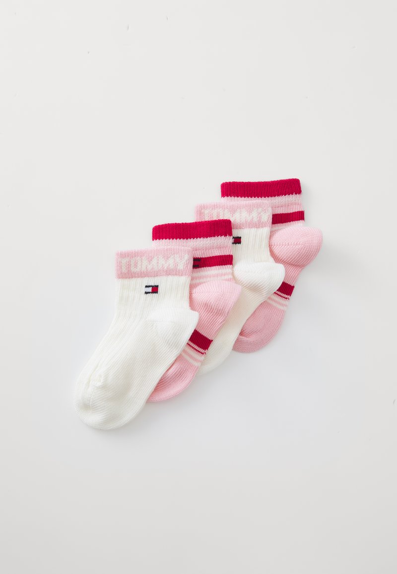 Sett med fire sokker i hvit og rosa. Ribbet mansjett; to ensfargede rosa, en med striper og en med logo på hvit. Mykt strikket materiale.