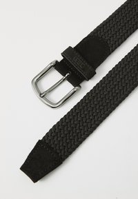 Sort vævet stofbælte med sølvmetalspænde og ruskindsdetaljer på hvid baggrund.