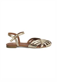 Goldene metallische flache Sandalen mit Kreuzriemen-Design, offener Zehe, knöchelhohem Riemen mit Schnalle und strukturiertem Lederfußbett. Flache Gummisohle.