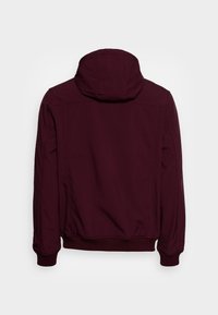 Vinröd huva jacka med en slät textur, ribbade ärmslut, elastisk midja och sömdetaljer, sedd bakifrån.