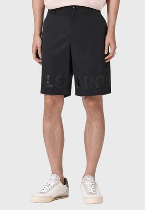 Sorte shorts lavet af letvægtsstof med en stor, gennemsigtig logo på tværs af kanten, designet med en klassisk pasform og forlommer.