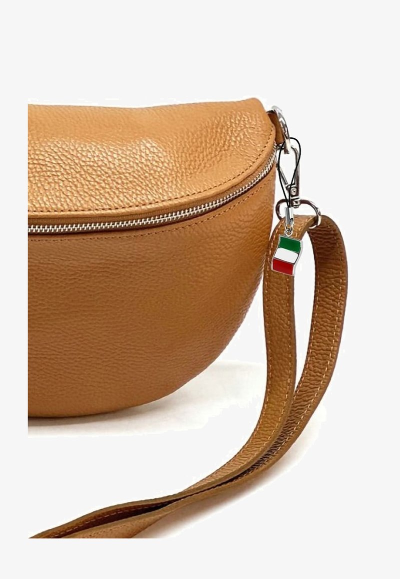Tan leren schoudertas met een ronde vorm, zilveren ritssluiting en een bedel met de Italiaanse vlag die aan de schouderriem is bevestigd.