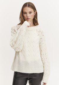 Cremfarbener Strickpullover mit einem strukturierten Diamantmuster, gerippten Bündchen und Saum, aus einem weichen Material gefertigt.