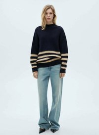 Maglione di maglia blu navy con ampie strisce crema in vita, abbinato a jeans dritti azzurri e scarpe nere con punta.
