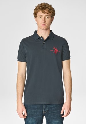 Polo shirt grigio scuro in cotone, con colletto a tre bottoni e logo rosso ricamato sul lato sinistro del petto. Maniche corte, texture liscia.