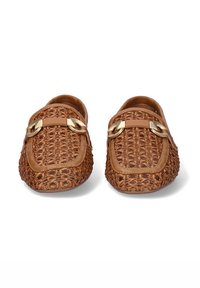 Mocasines trenzados marrones con acentos de hardware dorado, cuentan con una suela plana y una parte trasera abierta, mostrando una superficie texturizada y un diseño estructurado.