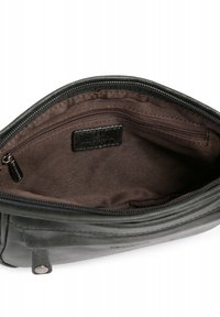 Interno di una borsa in pelle nera con una fodera in tessuto marrone. Presenta una tasca con zip e un piccolo etichetta con marchio. Design con bordi curvi.