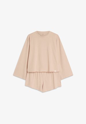 Jasnobeżowy zestaw odzieży domowej składający się z lekko skróconej bluzki z długim rękawem oraz dopasowanych szortów. Miękki materiał, luźny krój, bez wzorów.