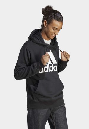 Schwarzer Kapuzenpullover mit Kängurutasche, Kordelzugkapuze und großem weißen Adidas-Logo auf der Vorderseite. Glatte Textur, lässige Passform und lange Ärmel.