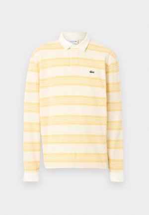 Polo à manches longues rayé jaune et blanc avec un col blanc et un petit logo crocodile vert sur la poitrine.
