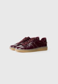 Baskets bordeaux avec une texture brillante à motif crocodile, dotées d'un système de laçage et d'une semelle en caoutchouc pour une meilleure adhérence.