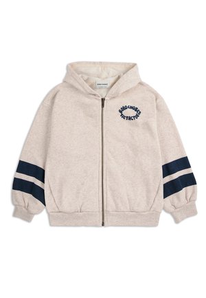Beige Kinder-Zip-Hoodie mit Kapuze, elastischen Bündchen, zwei dunkelblauen Streifen an jedem Ärmel und Textlogo auf der linken Brust.