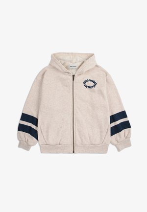 Felpa con zip beige per bambini, dotata di cappuccio, polsini elastici, due strisce blu scuro su ciascun manica e logo testuale sul lato sinistro del petto.