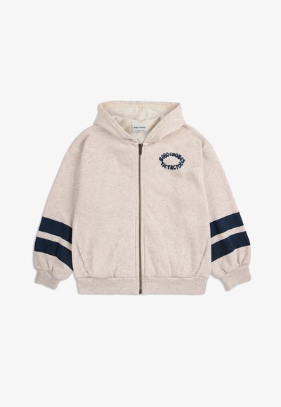 Felpa con zip beige per bambini, dotata di cappuccio, polsini elastici, due strisce blu scuro su ciascun manica e logo testuale sul lato sinistro del petto.