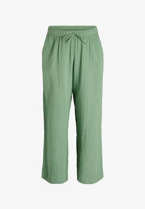 Pantalones de corte holgado en verde claro con textura, cintura elástica y cordón frontal, que cuentan con bolsillos laterales y un ajuste relajado.