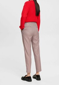 Röd stickad tröja, hög midja, rutiga byxor med bakfickor, slim fit, ankel-längd, kombinerat med svarta loafers.