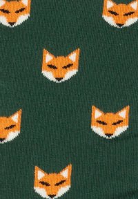 Tela verde con un patrón repetido de caras de zorro de dibujos animados en color naranja, con acentos blancos en las orejas y hocicos, textura suave.