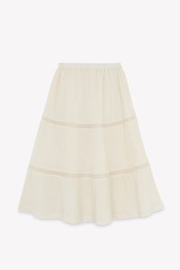 A cream-colored tiered skirt with an elastic waistband, featuring delicate mesh accents at the seams and a lightweight, textured fabric.