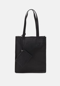 Sac cabas en cuir noir avec deux longues anses. Comprend une poche zippée attachée sur le côté. Texture lisse et design minimaliste.