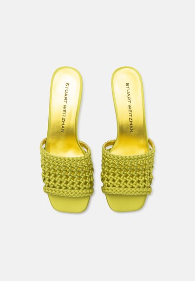 Sandales ouvertes à talons jaunes avec des brides tressées et le logo Stuart Weitzman sur la semelle dorée, vues de dessus sur fond blanc.