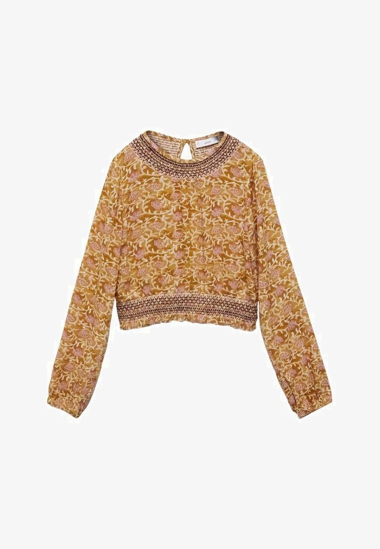 Långärmad, kort blus i senapsgul med blommönster. Har en texturerad hals med en nyckelhålöppning bak och elastiska ärmslut.