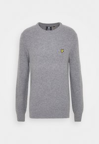 Pull gris en maille avec manches longues, col rond et finition texturée. Présente un petit logo jaune sur la poitrine.
