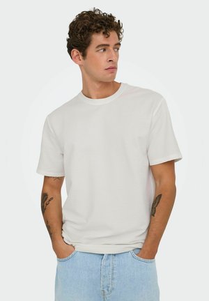Light gray cotton t-shirt with textured fabric, short sleeves, and a crew neck, paired with light blue denim shorts.