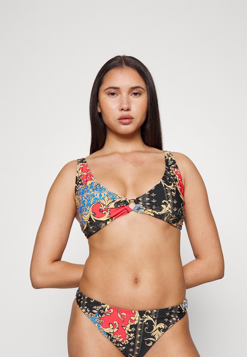 Conjunto de bikini com um padrão multicolorido com detalhes em preto, vermelho e azul. O top tem alças largas e um detalhe em metal circular no centro.