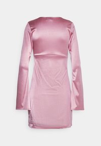 Rosa långärmad klänning med en figurnära silhuett, tillverkad av ett glänsande, slätt material. Bakom finns en enkel, rundad halsringning.