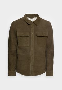 Olivgrön mockajacka med knäppning fram, spetsig krage, två bröstfickor och sydda detaljer på axlarna.