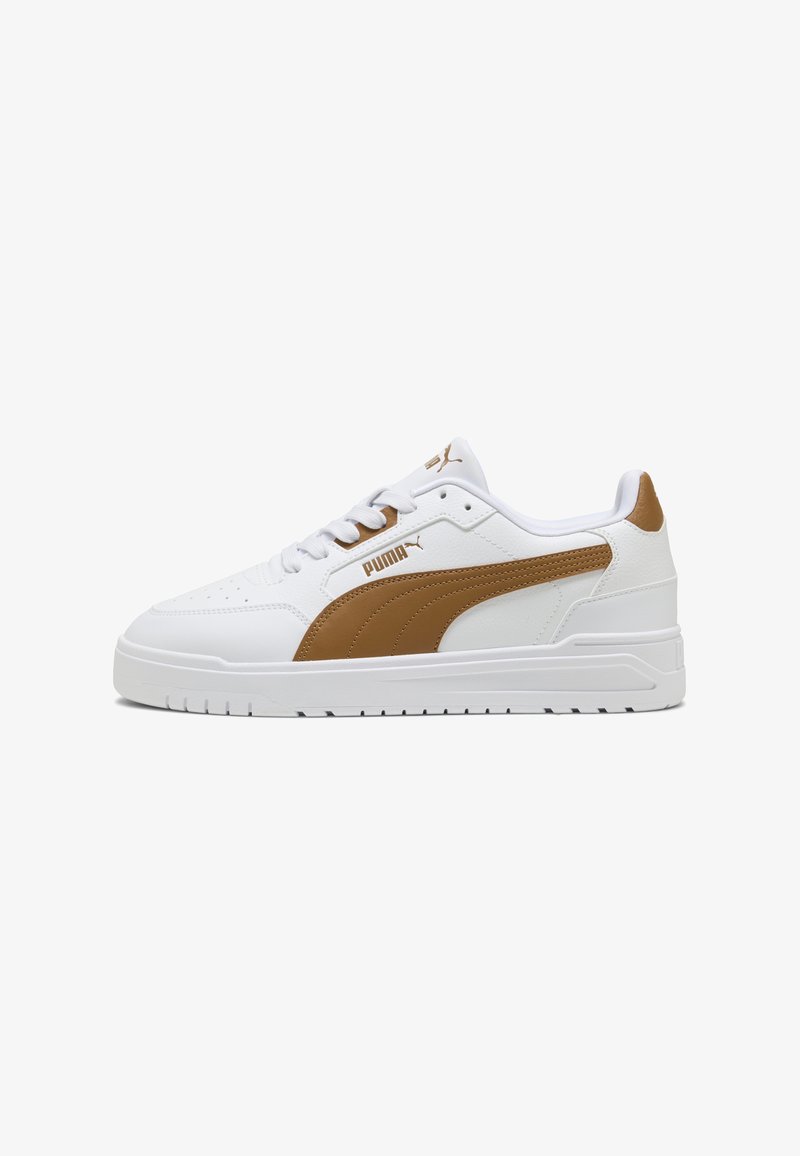 Baskets basses blanches Puma avec bande latérale marron, lacets blancs et accents marron au talon et sur le logo de la languette.
