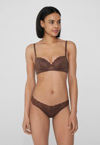 Ensemble de soutien-gorge et culotte en dentelle marron avec un motif floral, des bords festonnés et des bretelles réglables sur le soutien-gorge. Texture douce pour plus de confort.