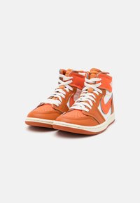 Höga sneakers gjorda av orange läder med vita accenter, med en vit swoosh, vadderad krage och texturerad sula.